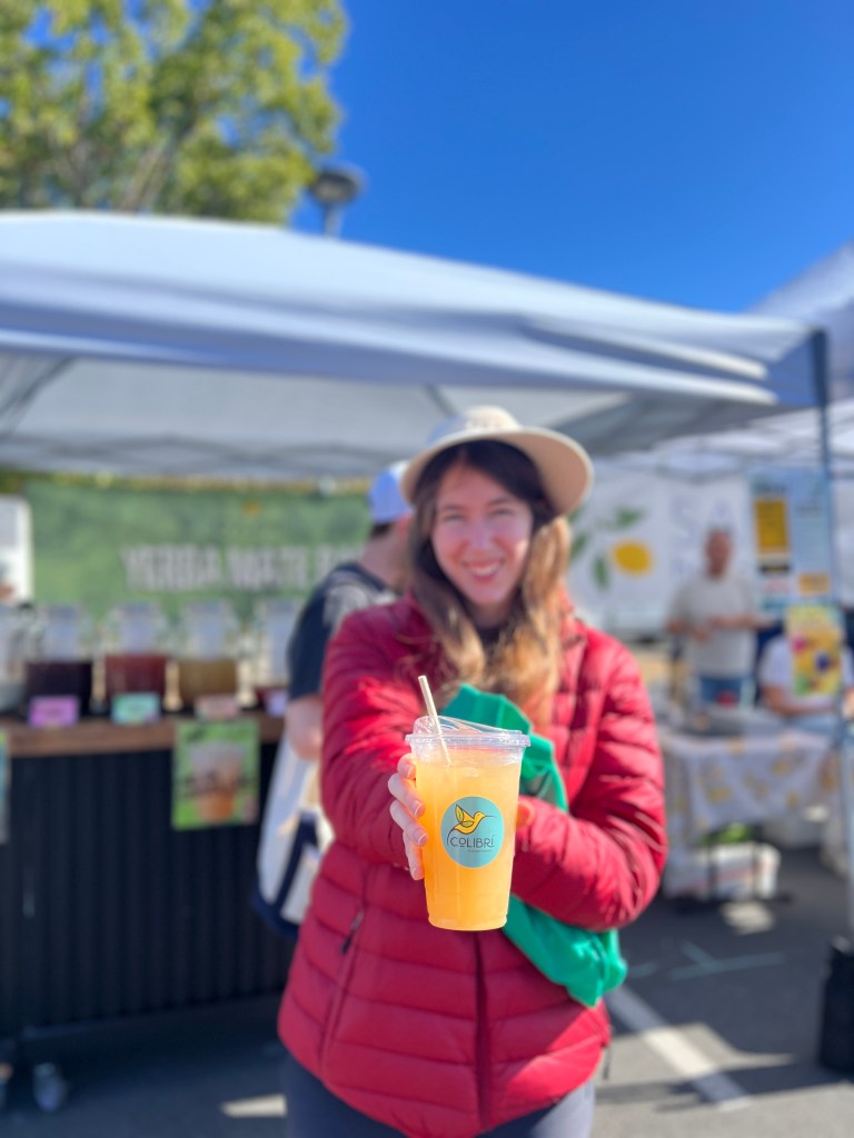 woman smiling and holding a cup of Colibri Yerba Mate